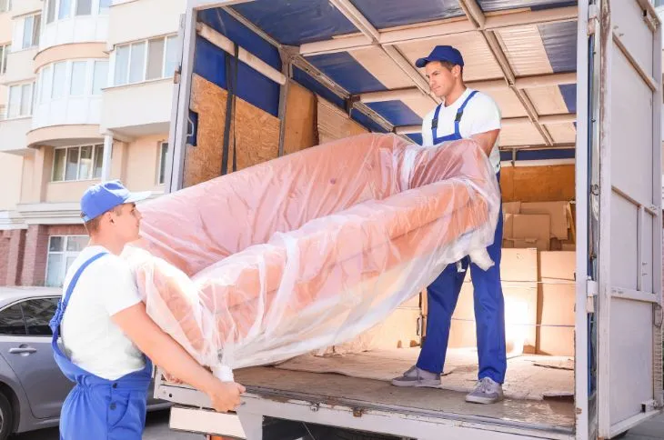 Möbelpacker entladen Sofa aus LKW